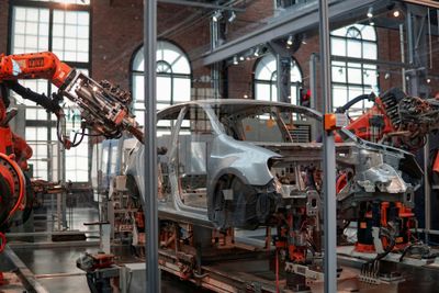 Autoindustrie Ein Auto, das von einem Roboterarm zusammengebaut wird.