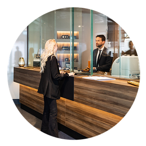 Begrüßung der Kund:innen Eine Frau wird am Empfang von einem Herrn begrüßt