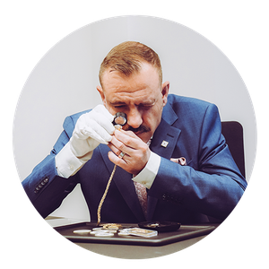 Bewertung von alten Schätzen Ein Mann bewertet eine alte Kette