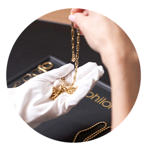 Schmuck für die Bewertung Eine Frau hält eine Halskette zur Bewertung in der Hand