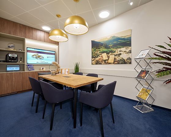 A consultation room with a meeting table and chairs and a dark blue floor.