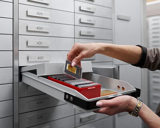 Eine Dame legt Ihren philoro Goldbarren in ein philoro Schließfach.