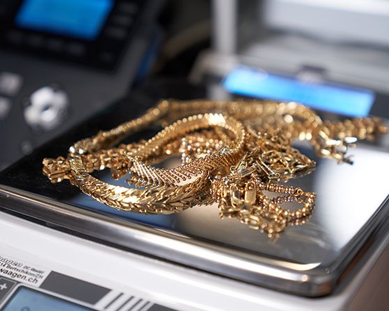 Goldschmuck liegt auf einer Waage.