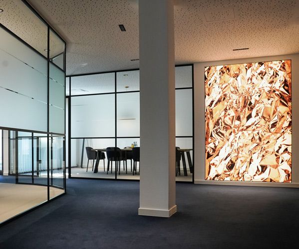 Ein Foto des Ganges zu den Beratungsräumen mit Blick auf ein hinterleuchtetes edles Bild mit Goldfolie.