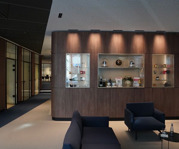 Ein Foto des Wartebereichs der philoro Filiale in Düsseldorf. Gemütliche Sitzgelegenheiten und Vitrinen mit Produkten laden darin zum Verweilen ein.