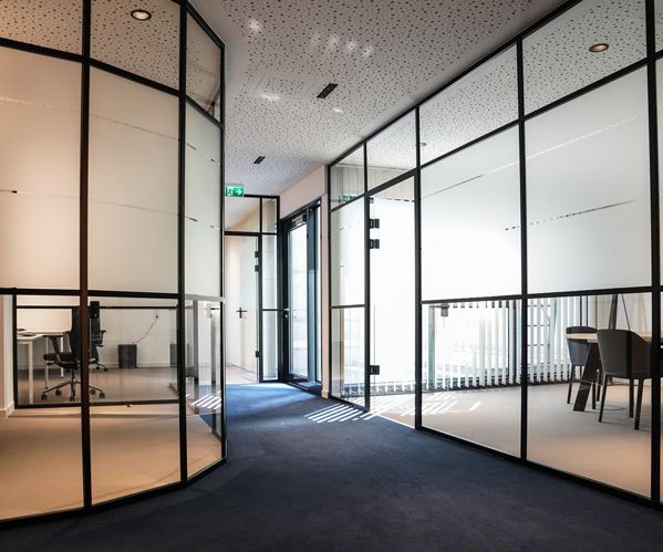 Ein Foto des Ganges zu den Beratungsräumen, die mit Glaswänden abgetrennt sind in der philoro Filiale in Düsseldorf.