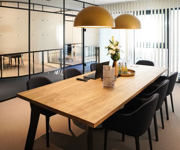 Ein Foto des Beratungsraumes mit großen Besprechungstisch und Stühlen in der philoro Filiale in Düsseldorf.
