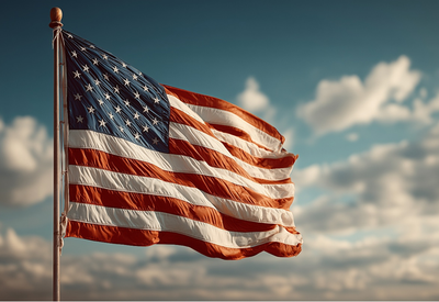 Die Flagge der USA vor wolkigem Himmel.