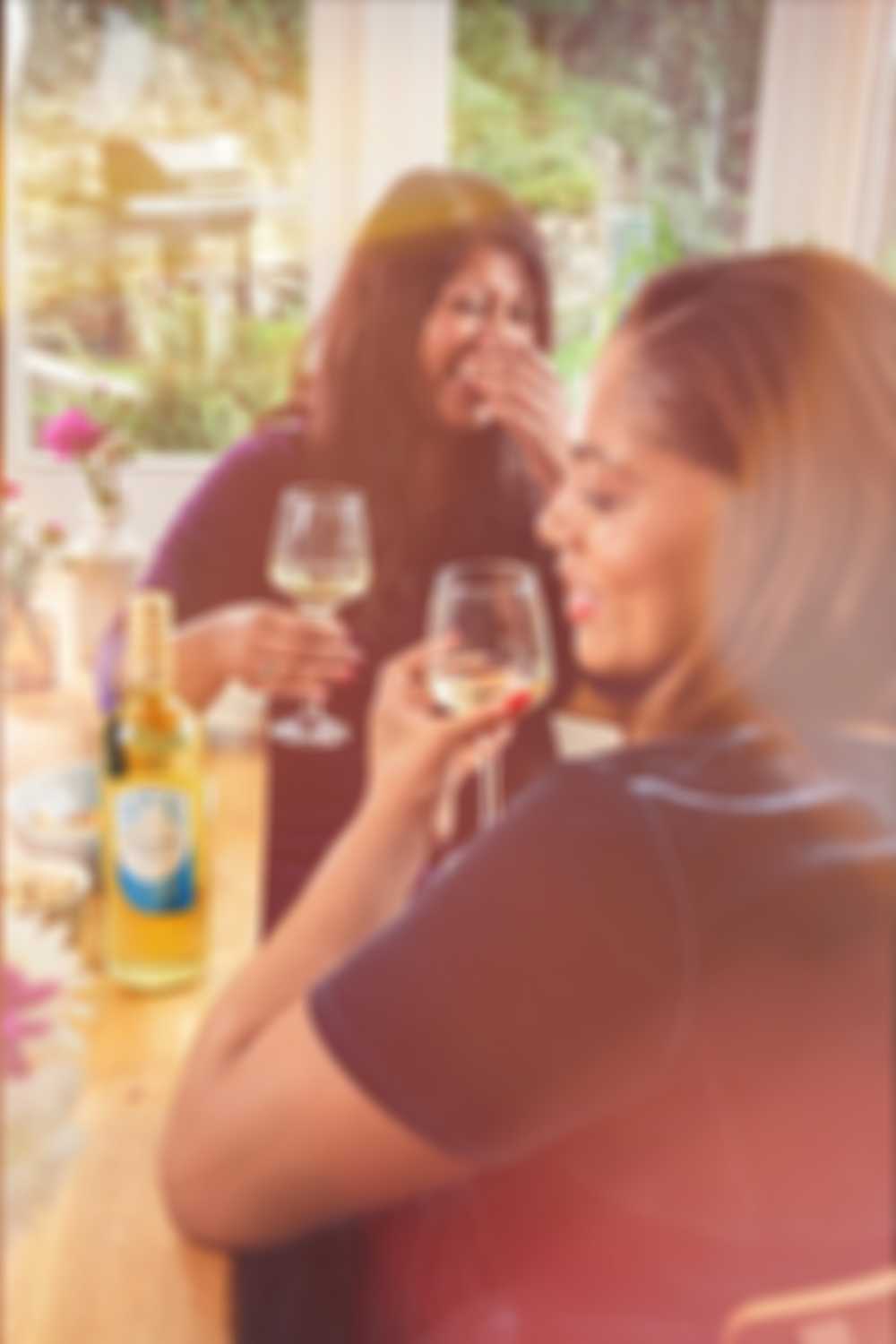 Friends laughing and drinking wine