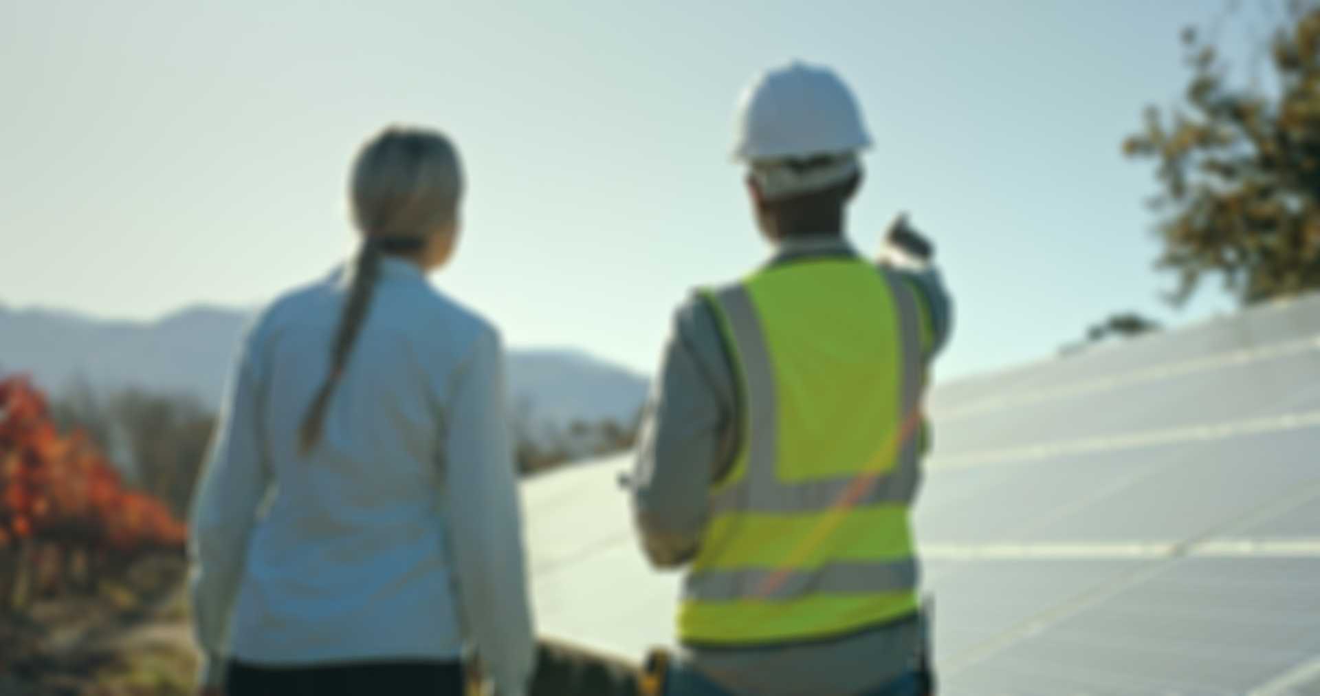 Staff members standing in front of solar panel