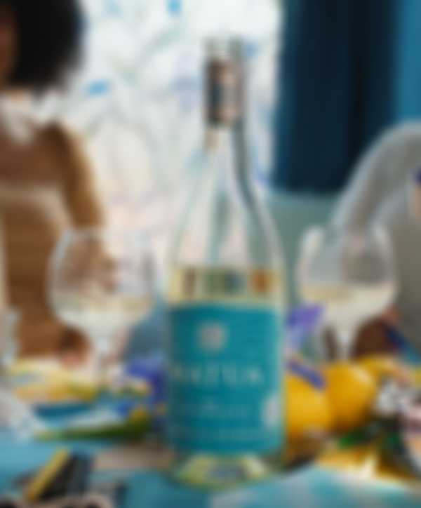 Bottle of Matua Sauvignon Blanc and two wine glasses on table