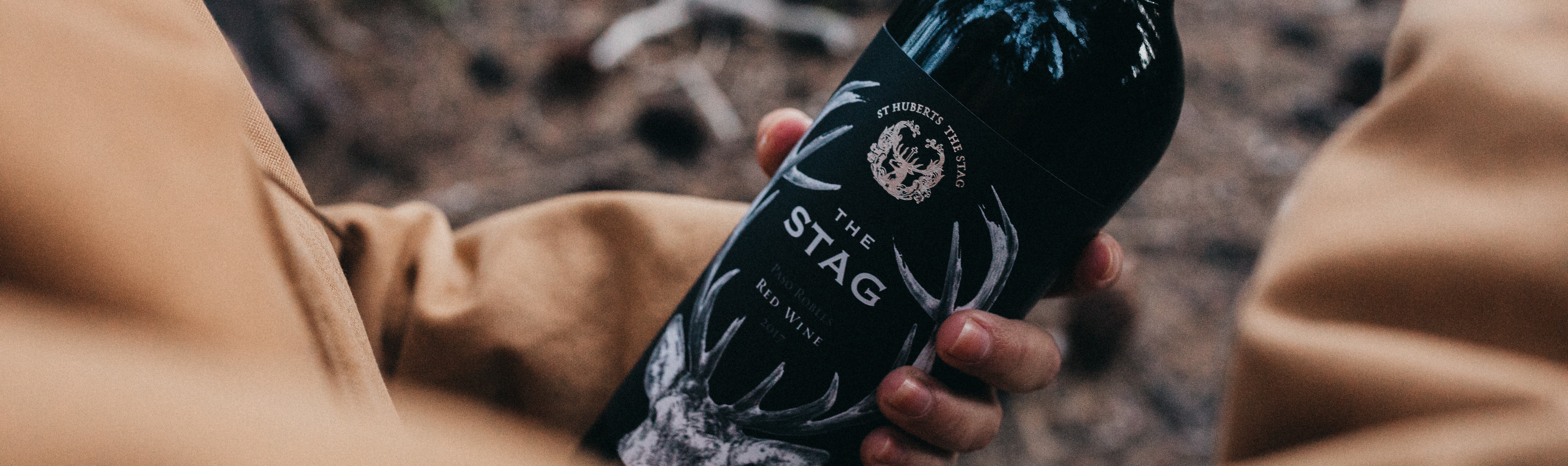 Man holding a bottle of The Stag red wine