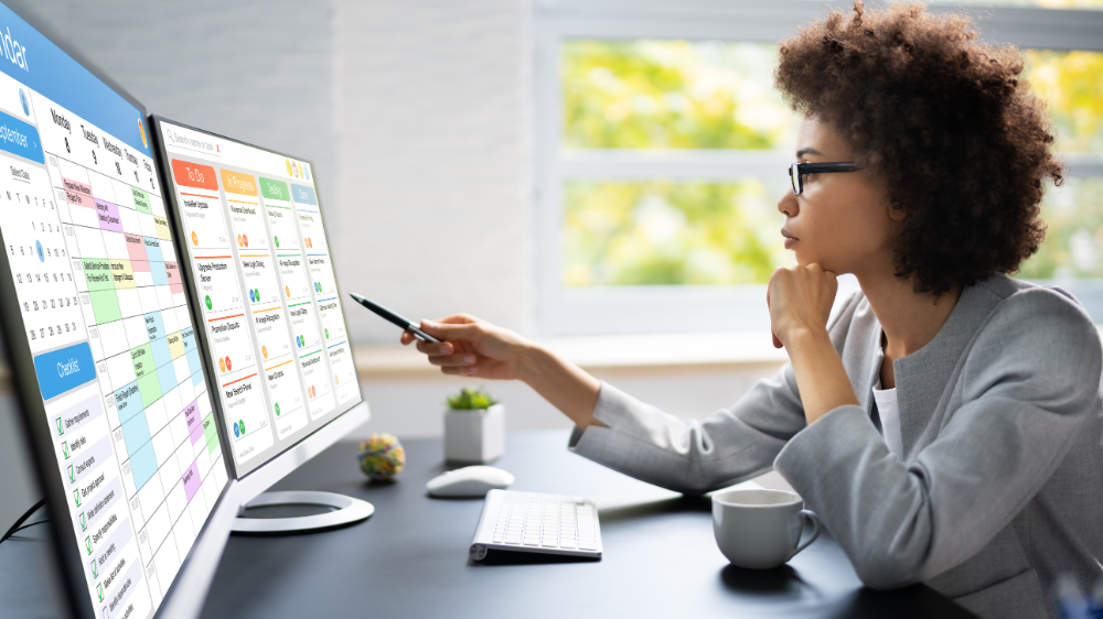 Gestora revisando KPIs de transporte en pantallas con datos de flota