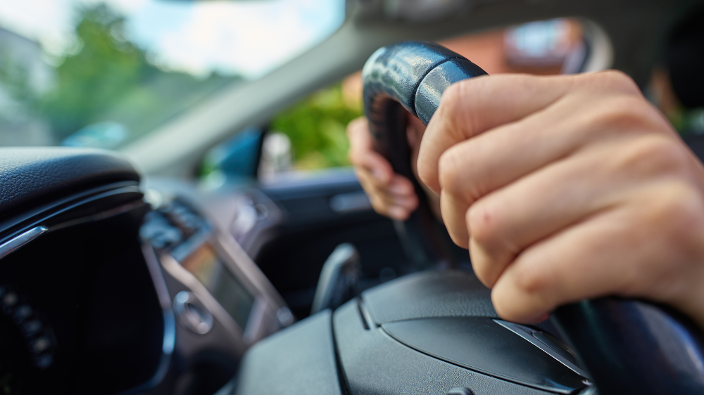 Primer plano de un reloj de pulsera metálico dorado con esfera blanca texturizada, tres subesferas y fecha, usado para ilustrar la gestión de horas de conducción