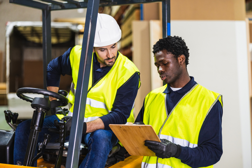 Cariste et responsable logistique en discussion — piloter l'exploitation avec un ERP transport