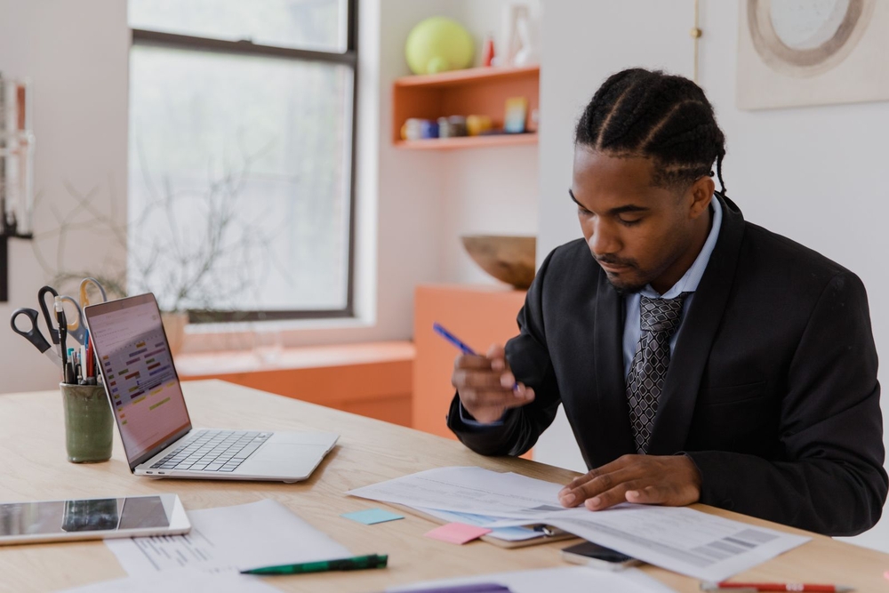Small carrier owner reviewing freight invoices and factoring paperwork in the office