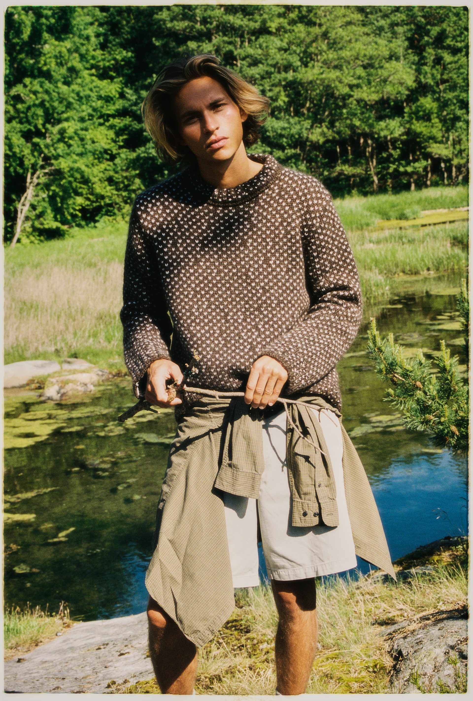 Seagulls perched on a rocky cliff, with one in flight above, against a textured stone background.