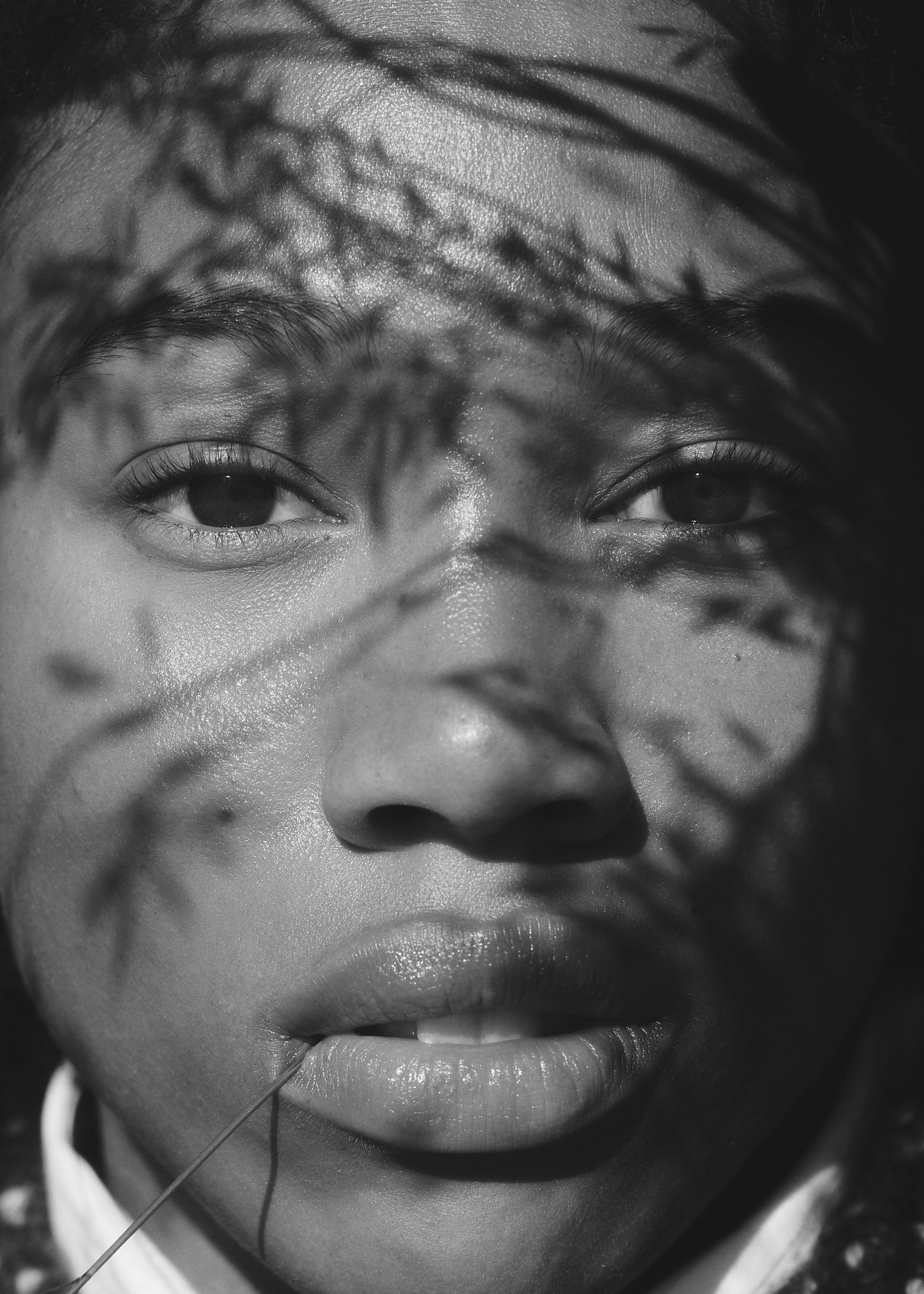 A black-and-white collage with a portrait of a man above a photo of a busy textile factory. A business card is centrally placed.
