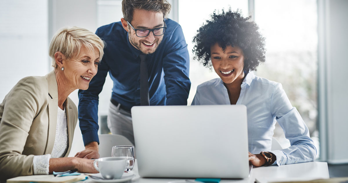 Drei Personen vor Laptop