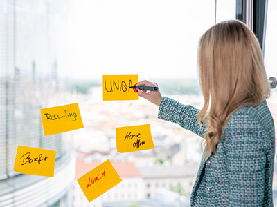 UNIQA MItarbeiter:in schreibt auf Notizzettel