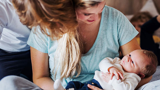 Mama mit Neugeborenem im Arm