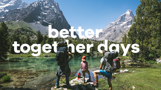 Drei Personen stehen vor einer Bergkulisse