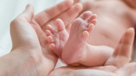 Hände halten Babyfuesse