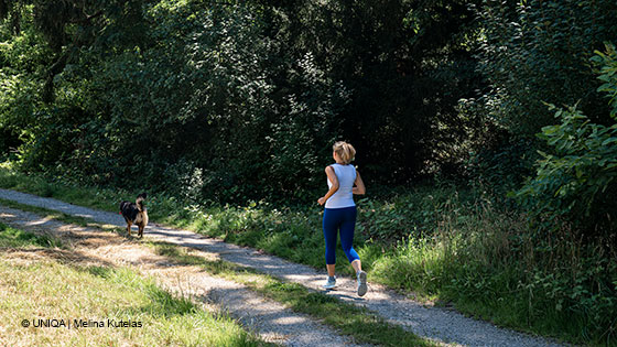 Frau mit Hund beim Joggen