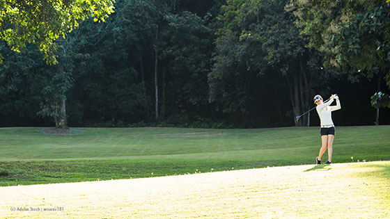 Golfspielerin am Green beim Abschlag