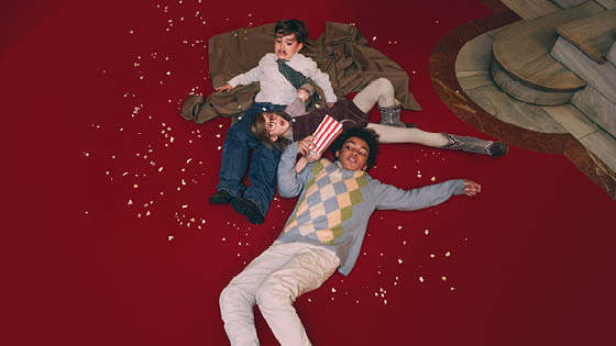 drei Kinder liegen am Boden