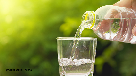 Wasser wird in ein Glas eingeschenkt