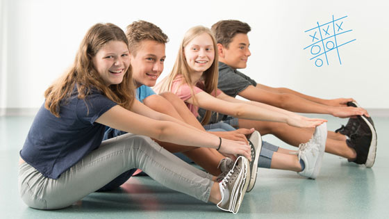 Kinder machen Beweglichkeitsübung sitzend am Boden