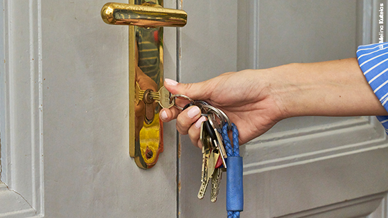 Person öffnet die Wohnungstüre mit einem Schlüssel
