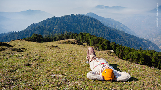 Person liegt auf einem Hügel