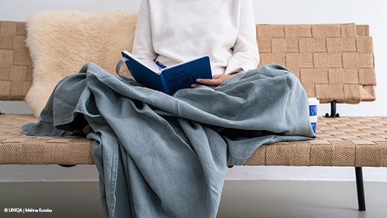 Person sitzt auf der Couch und liest