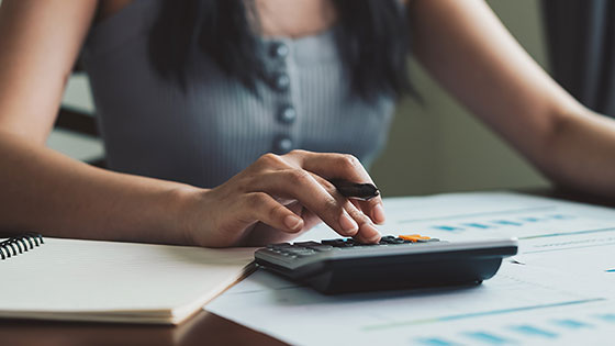 Frau organisiert Finanzen zu Hause und prüft Ausgaben für finanzielle Sicherheit und Pensionsvorsorge.