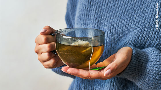 Glas Tee wird in einer Hand gehalten