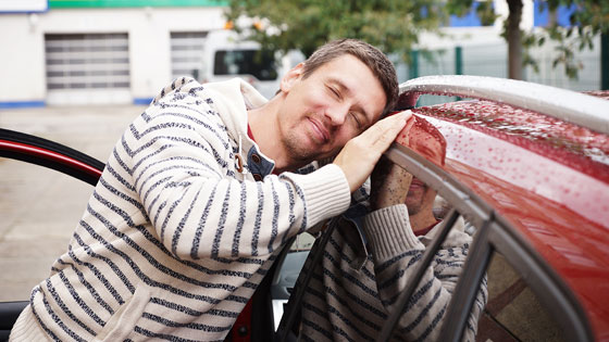 Mann streichelt sein Auto
