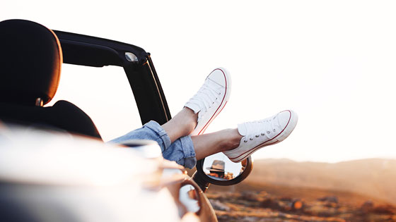 Frau mit Sneakers im Auto