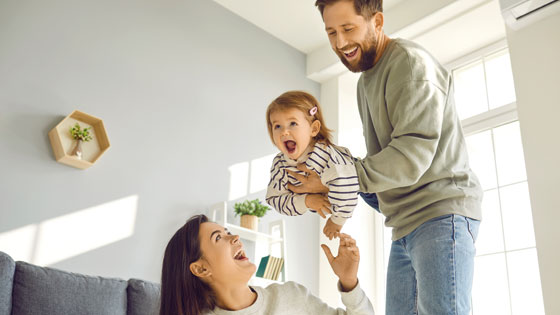 Jungfamilie spielt im Wohnzimmer