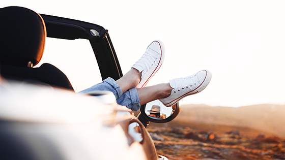 Füsse werden aus dem geparkten Auto gestreckt