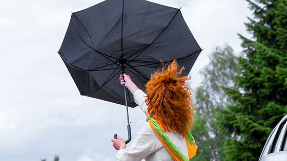 Frau mit Regenschirm im Sturm