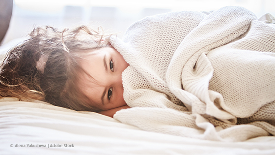 Muedes Kind unter der Kuscheldecke