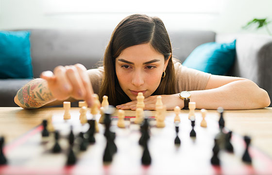 Eine Frau führt ihren Spielzug am Schachbrett aus