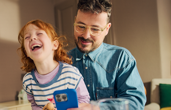 Papa und Kind begutachten das Smartphone