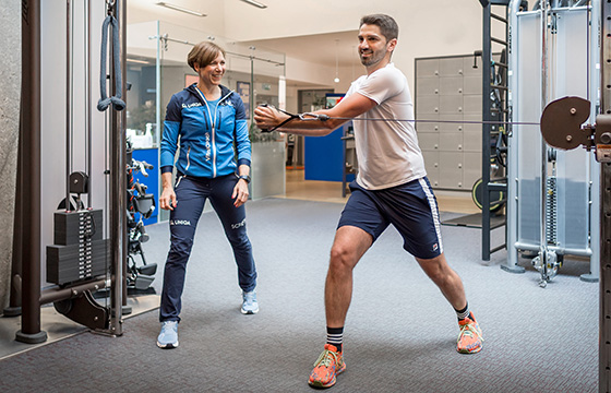 UNIQA VitalCoach und Mann beim Krafttraining