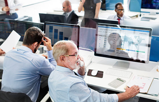 Bürosituation. Zwei Männer sitzen vor Ihrem Computer an den Schreibtischen.