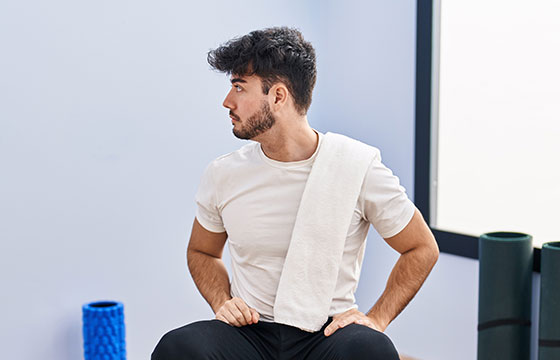 Mann sitzt auf einem Sessel und macht Bewegungsübungen