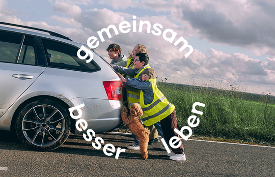 Familie und Hund schieben Fahrzeug