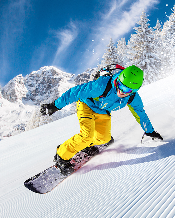 Snowboarder:in in den Bergen im Schnee